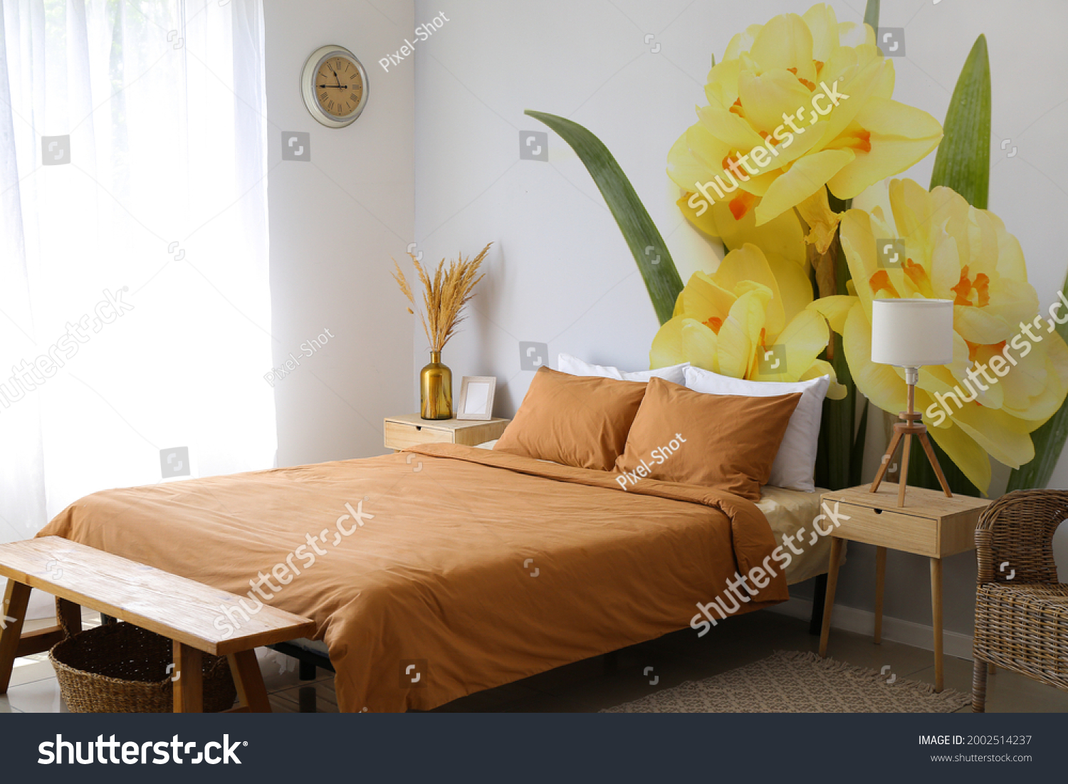 Stylish interior of bedroom with beautiful narcissus flowers on wall #2002514237
