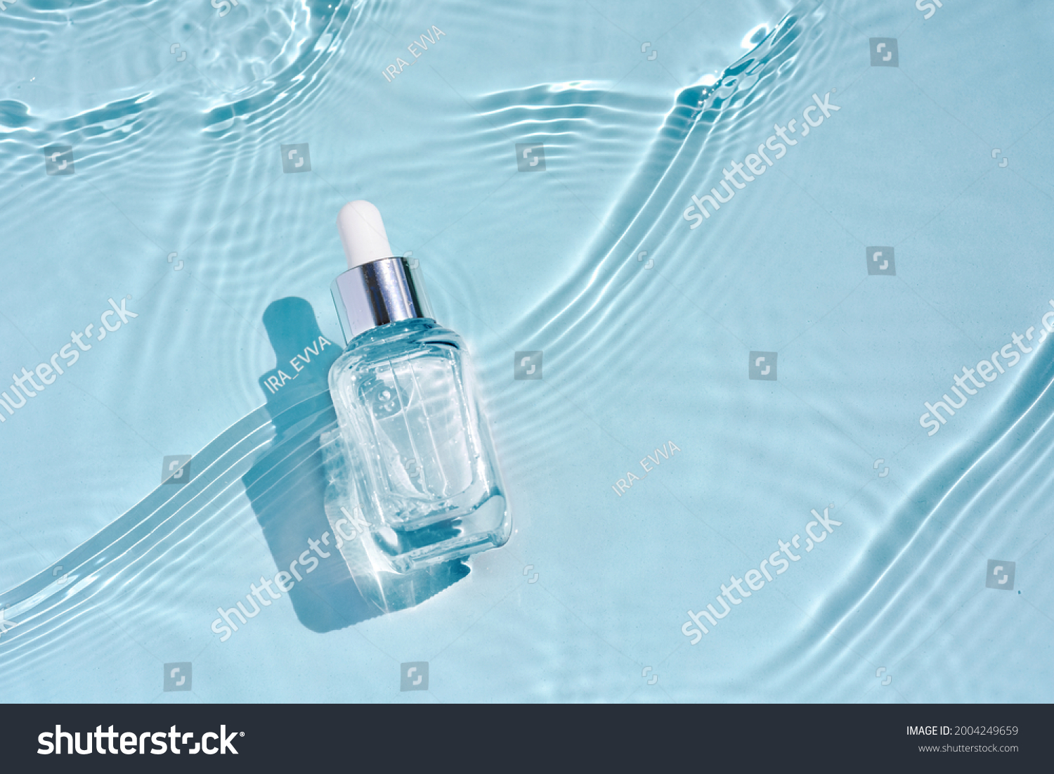 Cosmetic spa medical skincare, glass serum bottle with collagen on blue water background with waves. Advertising of medical product for anti-aging care, moisturizing and cleansing. #2004249659
