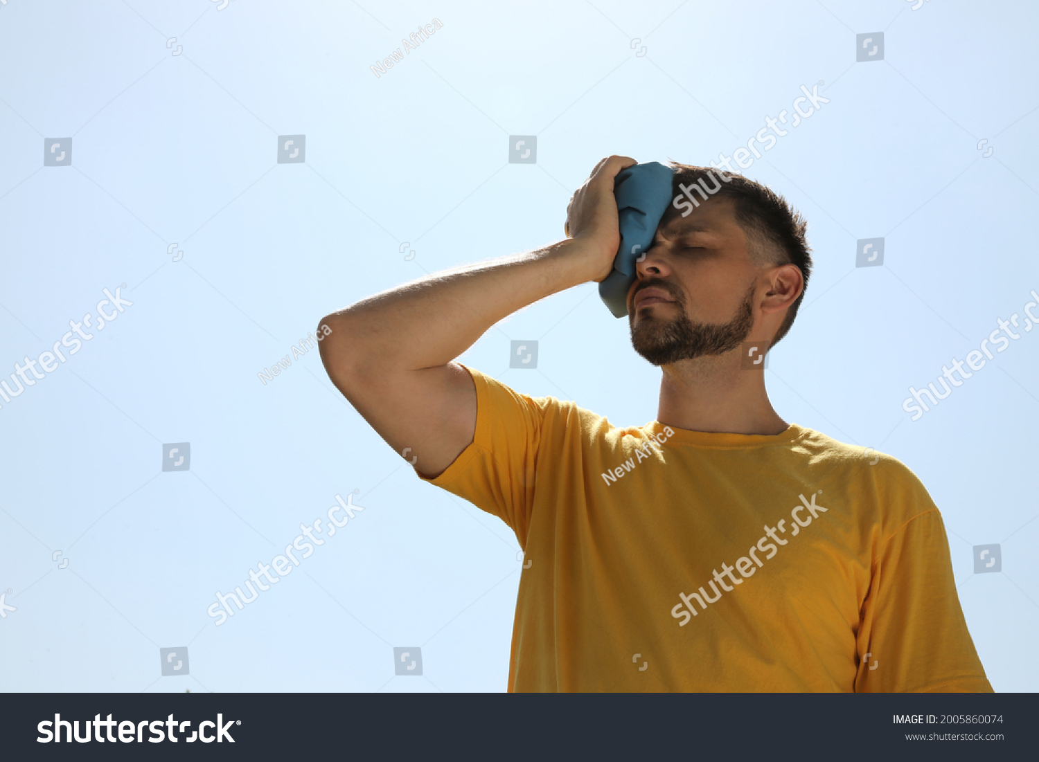 Man with cold pack suffering from heat stroke outdoors #2005860074