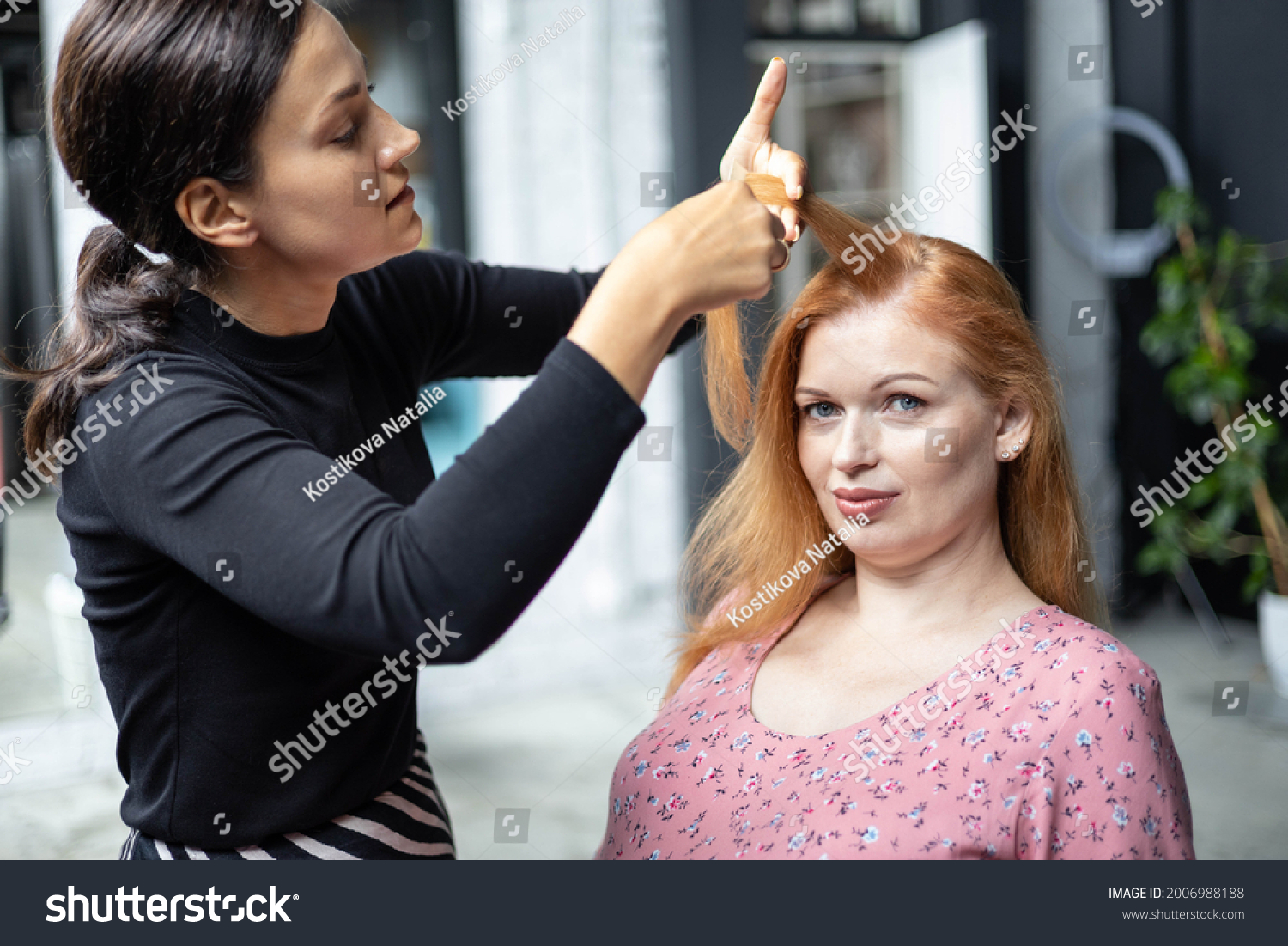 Professional female makeup artist applying cosmetics on model face use brush working at beauty salon. Woman visagist make up master dyeing facial visage to client appearance makeover #2006988188