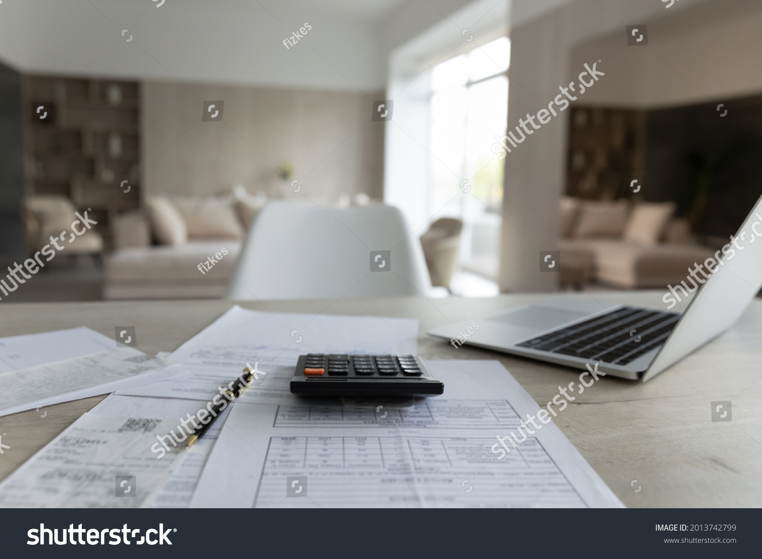 Close up of empty table at home with paper documents and bills for paying online on computer. No people, paper correspondence for managing budget or expenses, make payment on laptop. Finance concept. #2013742799