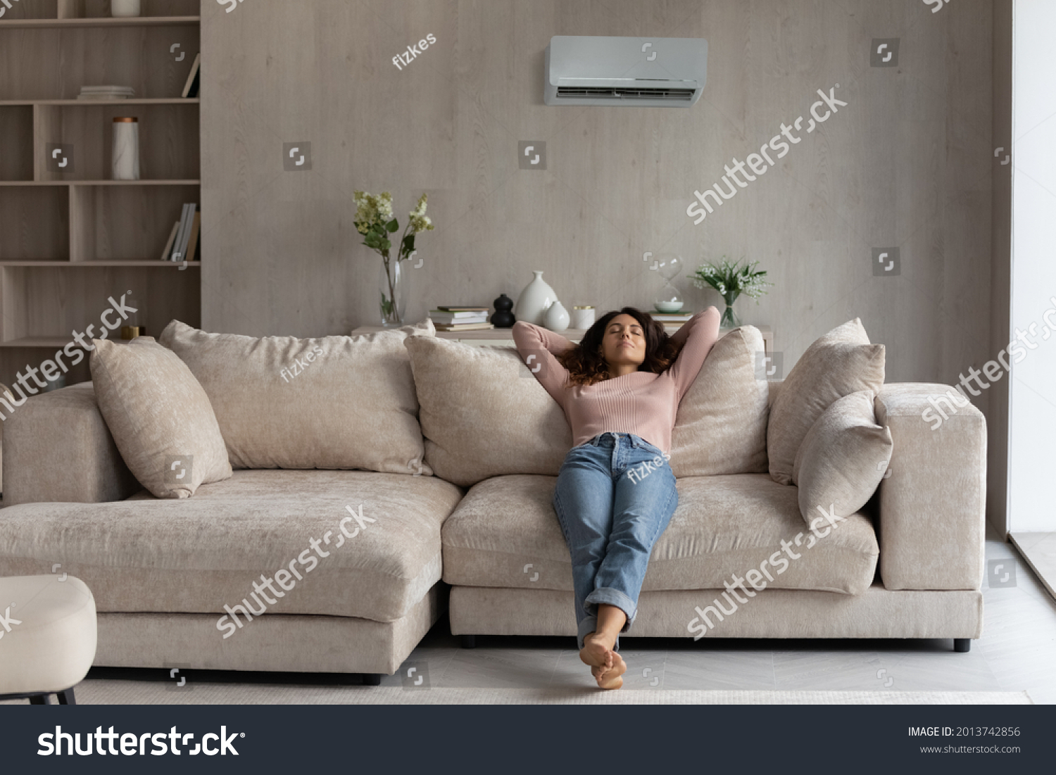 Calm millennial Latino woman lying relaxing on couch in living room breathe fresh ventilated condition air. Happy young Hispanic female renter rest on sofa at home relieve negative emotions. #2013742856