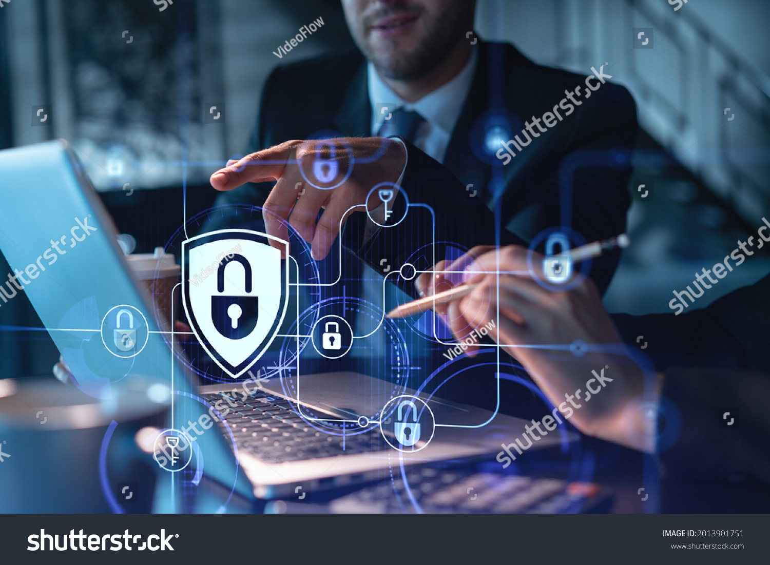 Two colleagues working together to protect clients confidential information and cyber security. IT hologram padlock icons modern office background at night time #2013901751