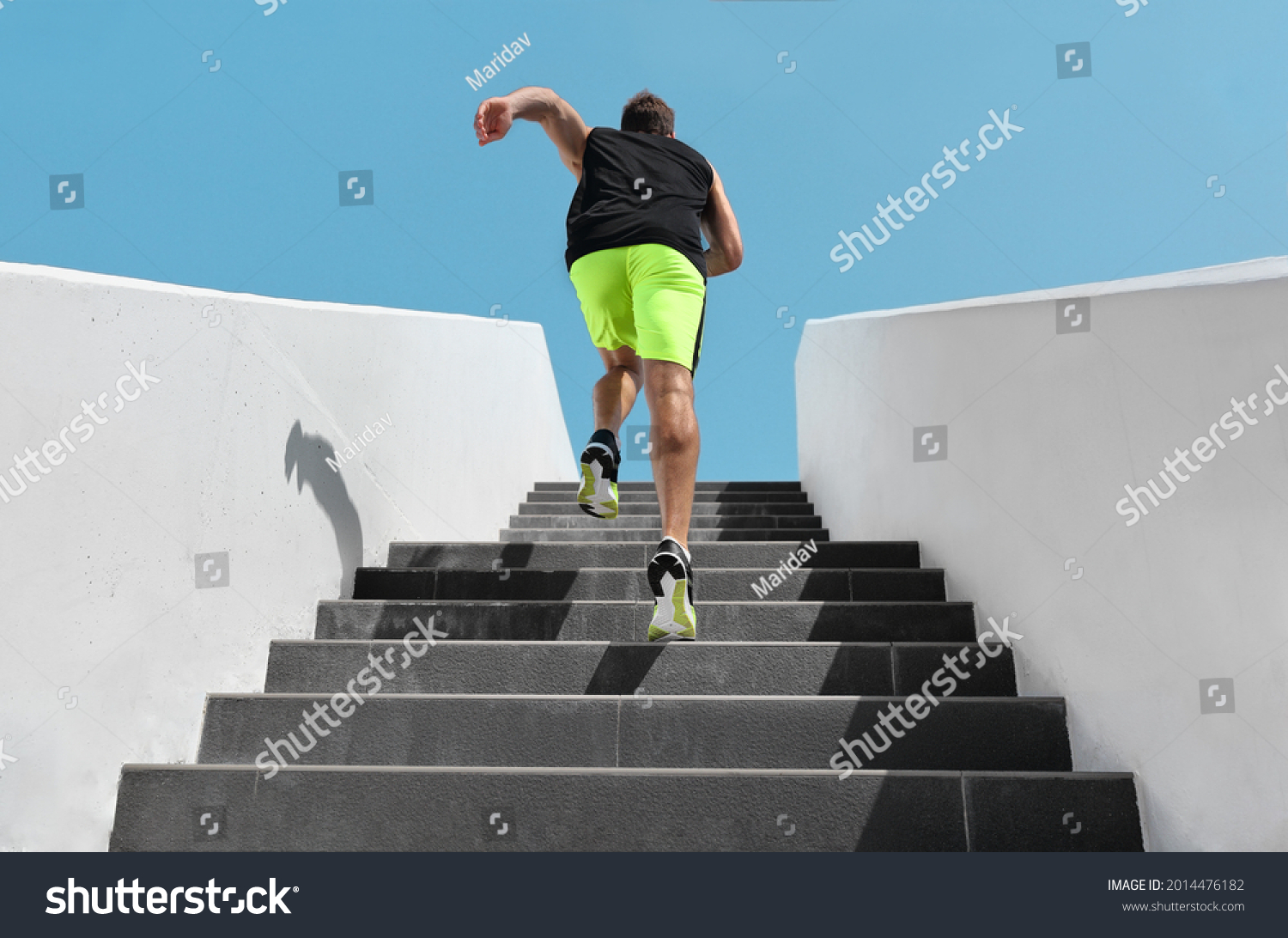 Stairs exercise fitess man running fast up the staircase for hiit cardio workout run at outdoor gym. Sport active athlete lifestyle training legs muscles. #2014476182