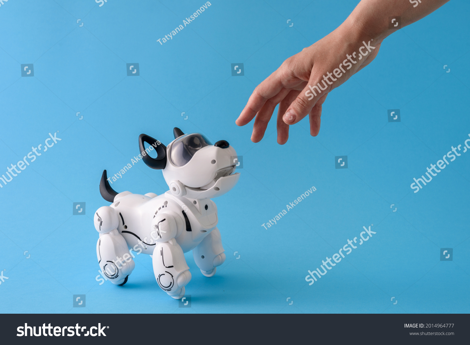 Robot dog pet on light blue background with human hand #2014964777