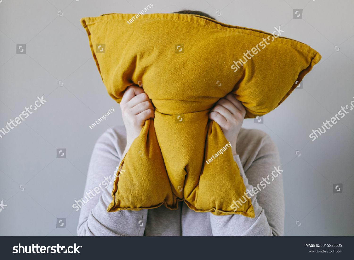 Woman squeezes a pillow with her hands, the concept of anger, irritation #2015826605