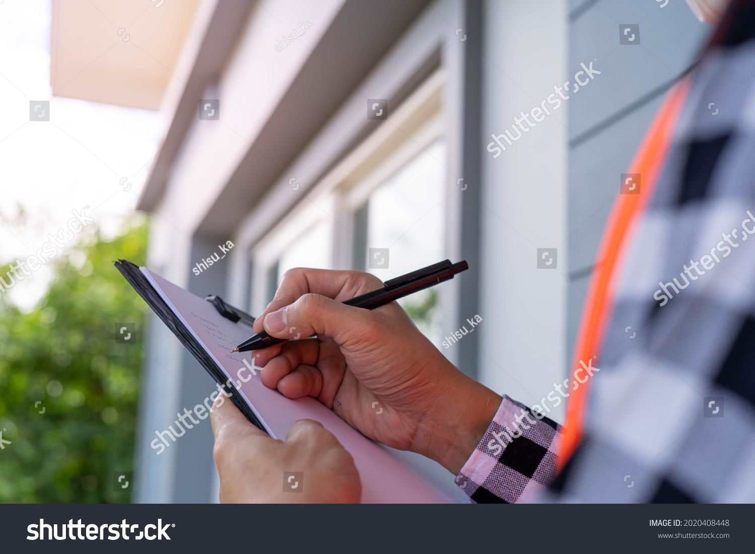 Inspector or engineer is checking and inspecting the building or house by using checklist. Engineers and architects work on building the house before handing it over to the landlord. #2020408448
