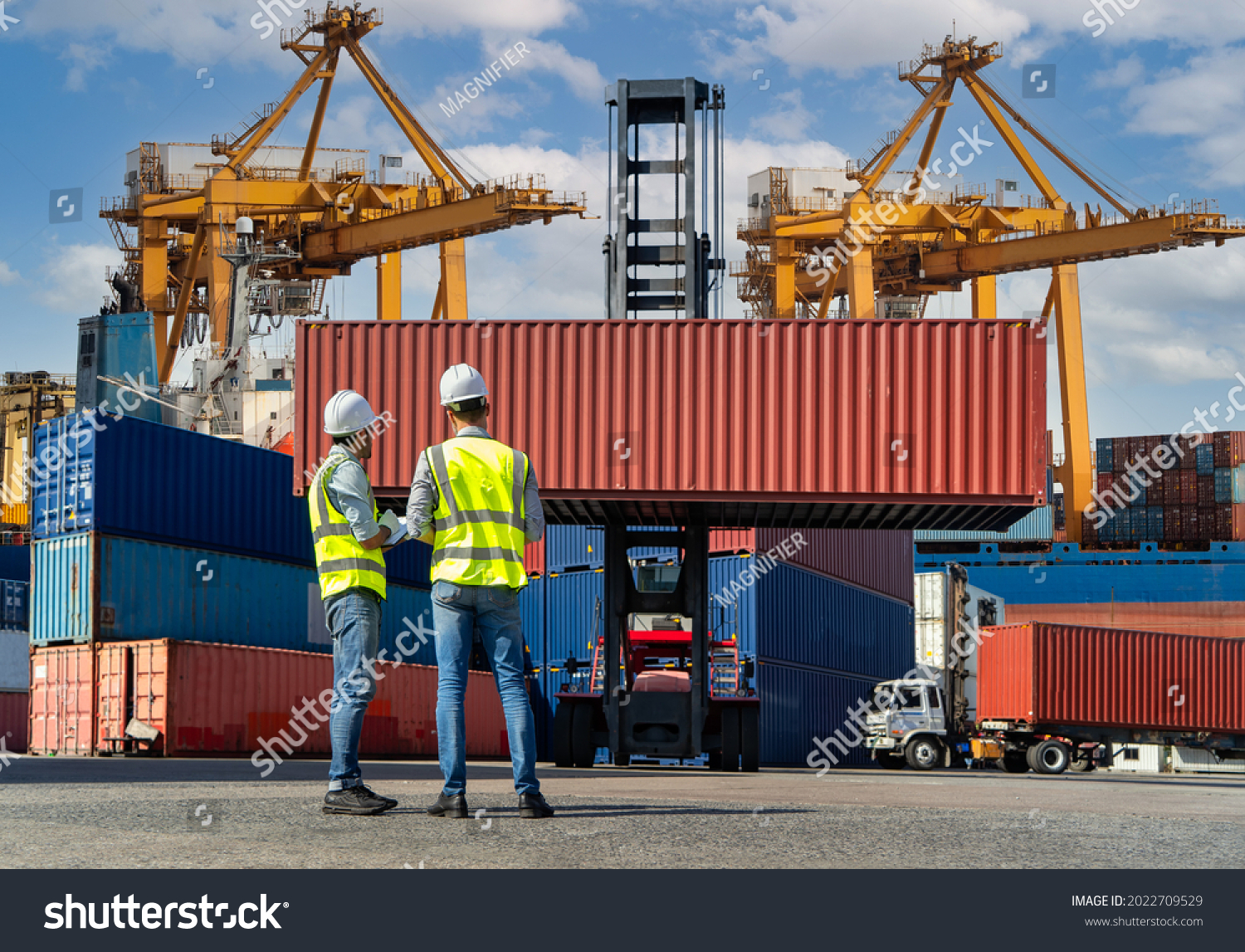Engineers are overseeing the transportation of cargo with containers inside the warehouse. Container in export and import business and logistics. #2022709529