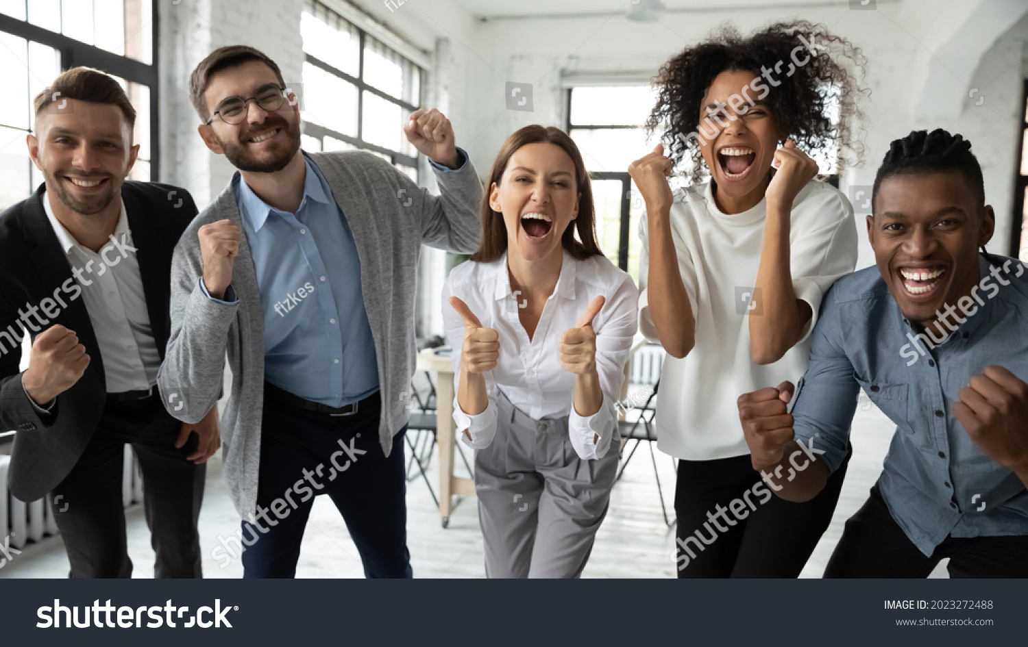 Portrait of overjoyed young diverse employees workers show thumb up recommend good quality company service. Smiling multiethnic colleagues celebrate shared business success or victory in office. #2023272488