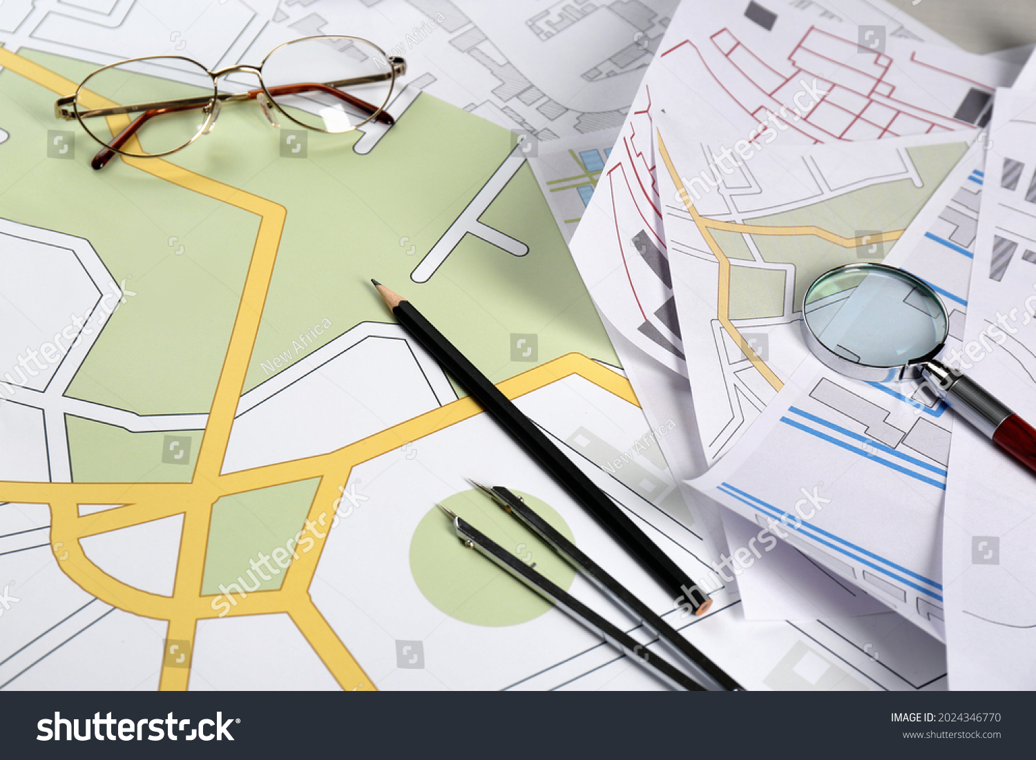 Office stationery and eyeglasses on cadastral maps of territory with buildings #2024346770