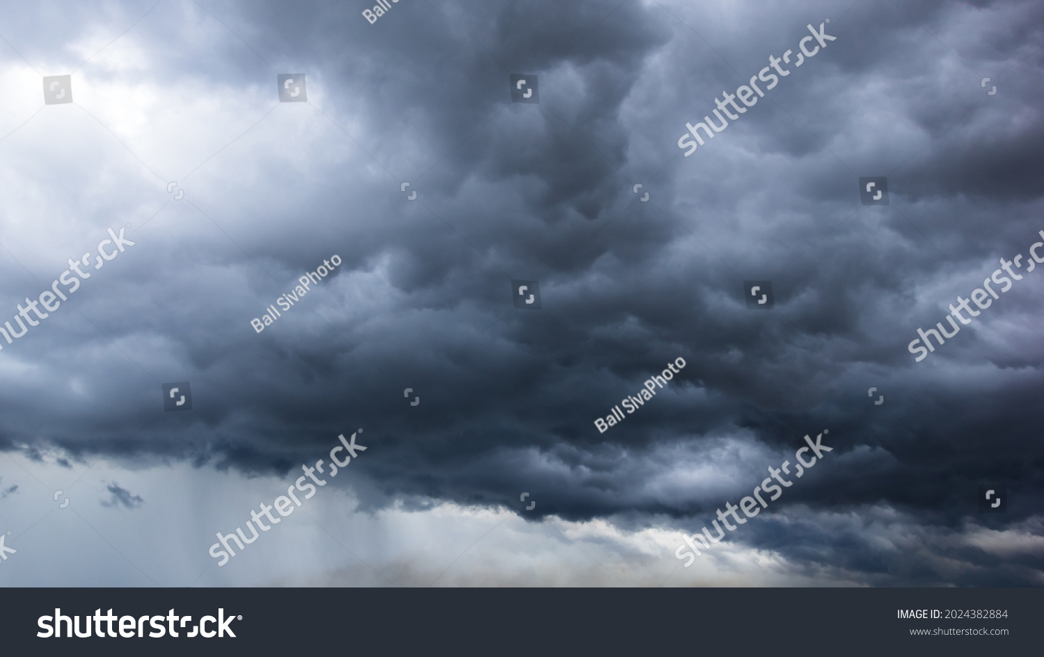 The dark sky with heavy clouds converging and a violent storm before the rain.Bad weather sky. #2024382884