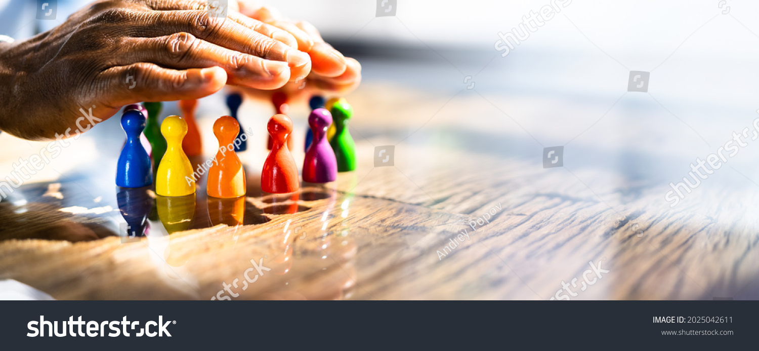 Inclusion, Diversity And Equality. African Hands Safeguard Wooden pawns #2025042611