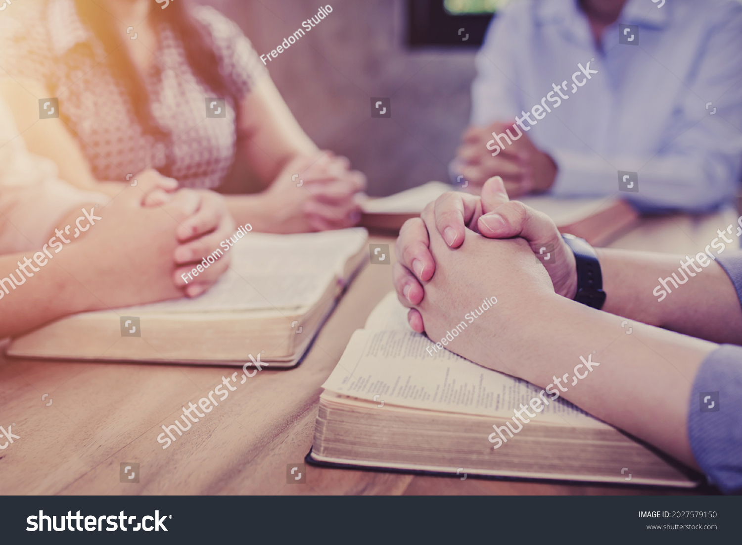 Close up of Christian groups are study bible and praying on the bible together around a wooden table in the home, Christian fellowship, or Cell group concept. devotional background with copy space. #2027579150