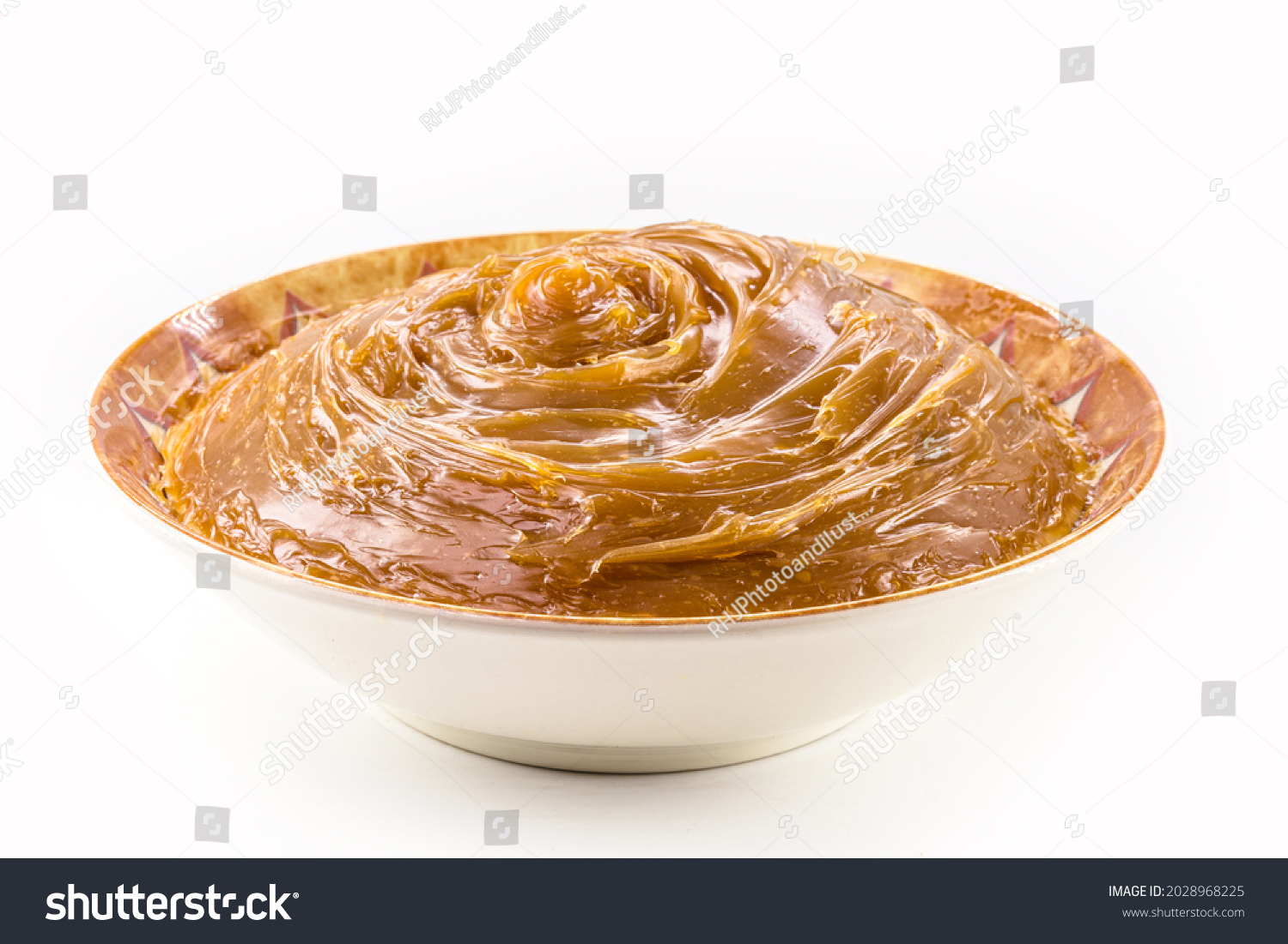 bowl with homemade dulce de leche, condensed cream or doughy caramel, isolated white background. #2028968225