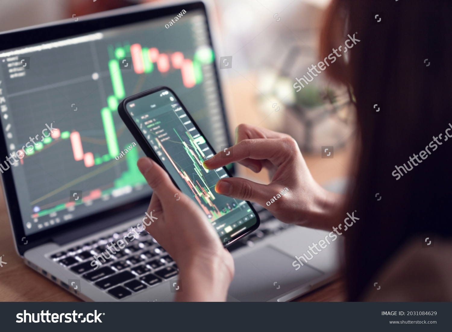 Closeup - Woman is checking Bitcoin price chart on digital exchange on smartphone, cryptocurrency future price action prediction. #2031084629
