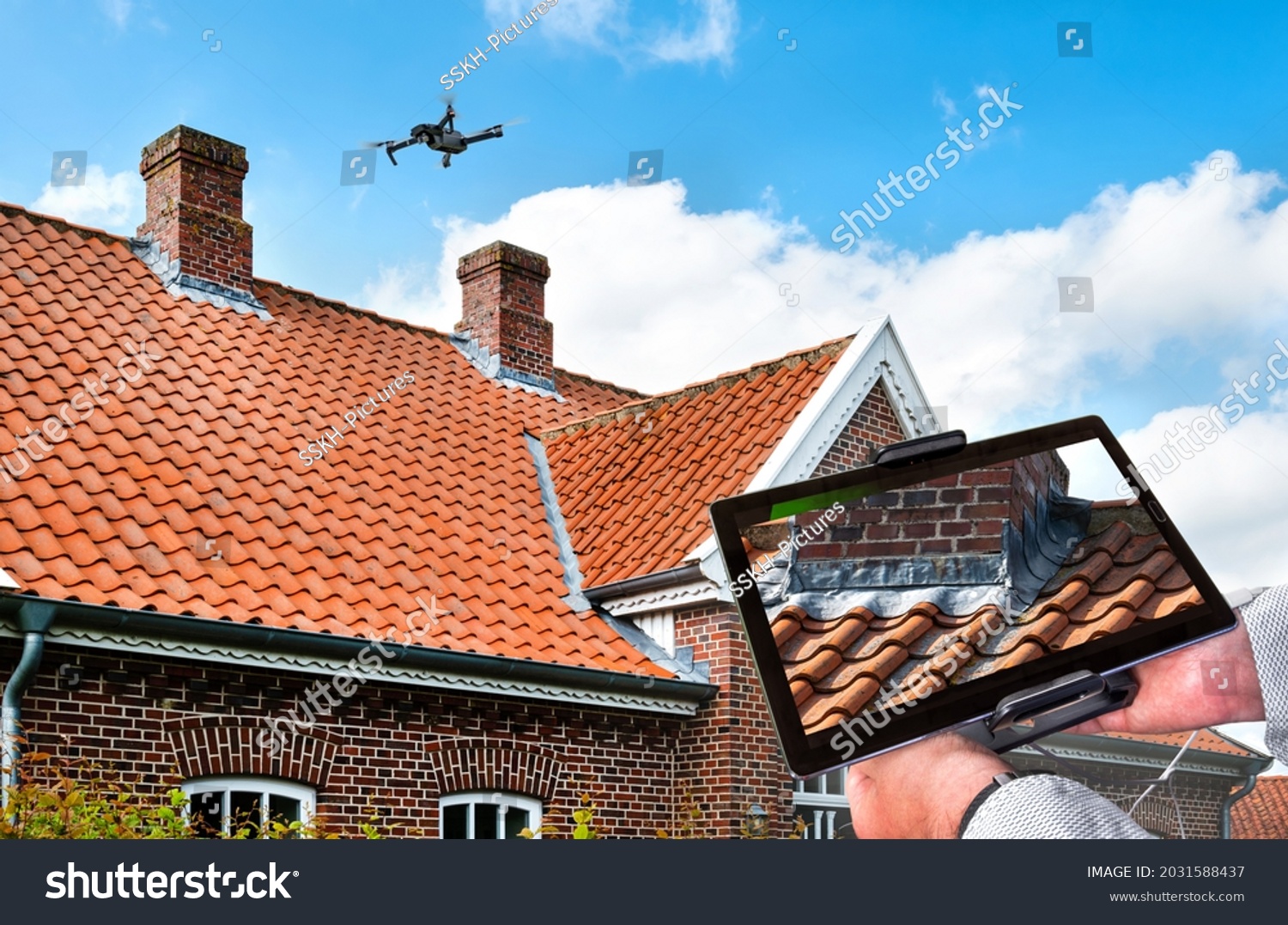 Drone in the air inspecting the roof over the house. Close-up of drone and roof. #2031588437