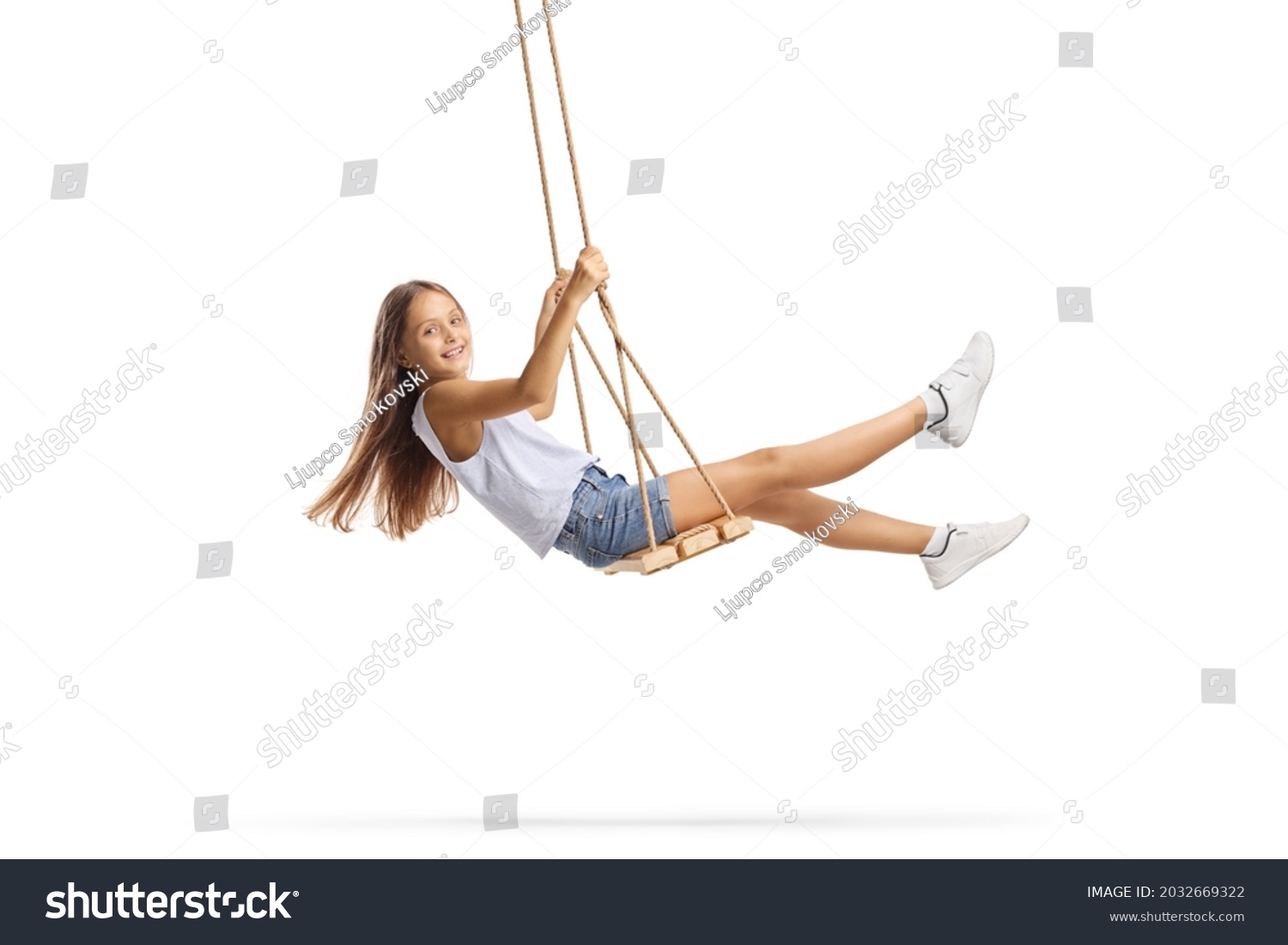 Beautiful girl with long hair swinging on a wooden swing isolated on white background #2032669322