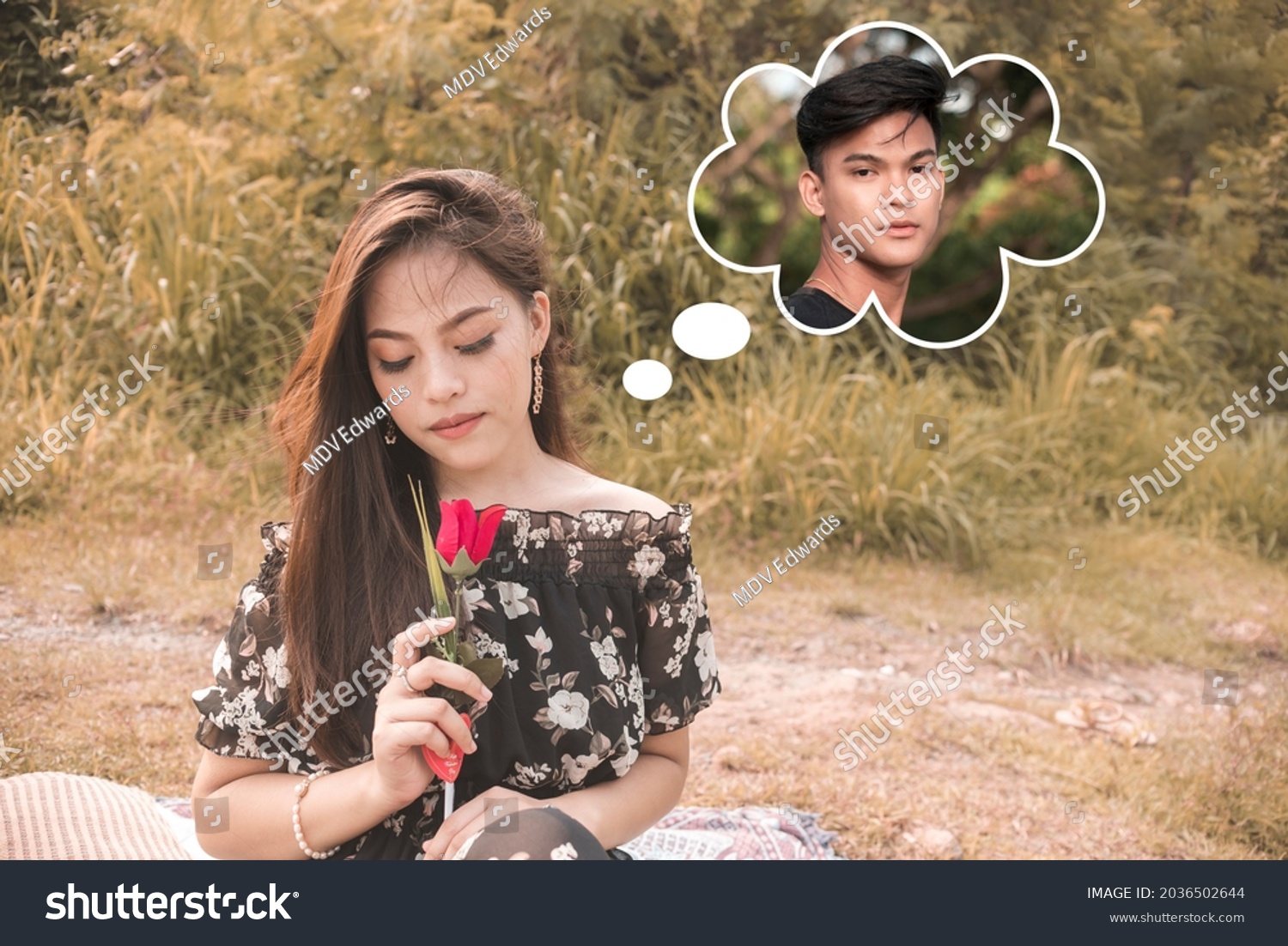 A beautiful woman remembers her boyfriend while smelling a rose. Missing and longing her man.Outdoor scene. #2036502644