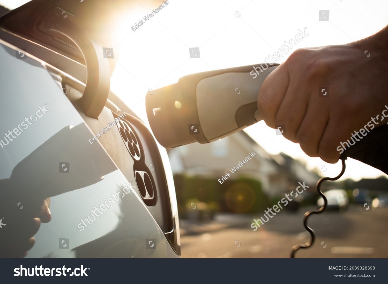 Electric car charging with sun in the background #2039328398