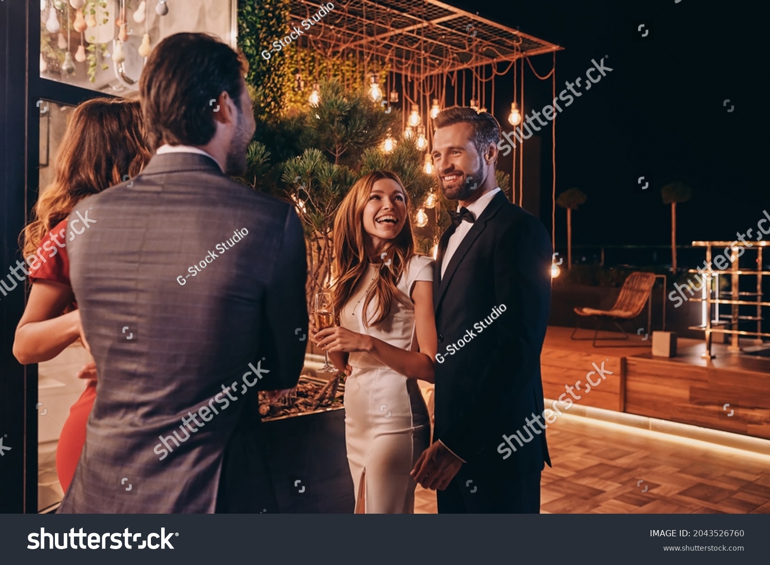 Group of people in formalwear communicating and smiling while spending time on luxury party #2043526760