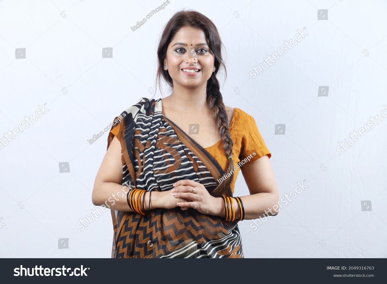 Young rural happy Indian woman wearing a saree portraying various expressions of the village girl. She is portraying various moods of cheerful rural life in white background. #2049316763