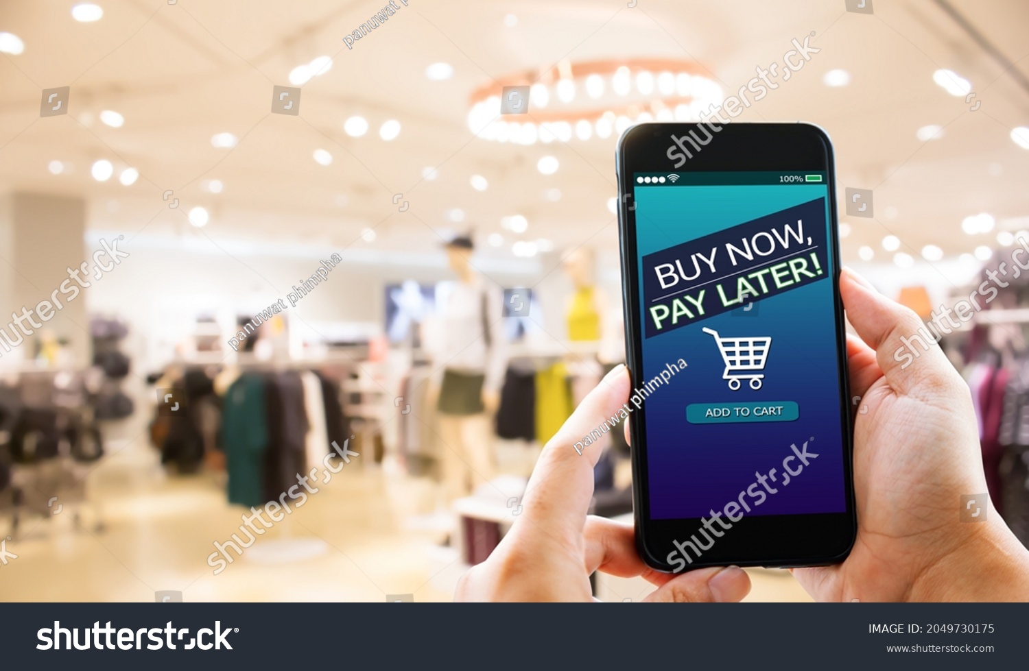 BNPL Buy now pay later online shopping concept.Hands holding mobile phone on blurred store as background #2049730175