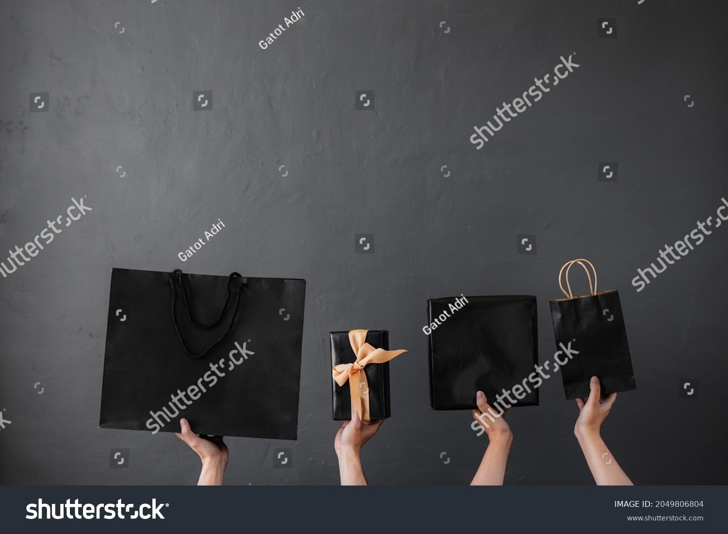Crop of hand holding shopping bag or goodie bag for shopaholic online shopping background and black friday promotion #2049806804