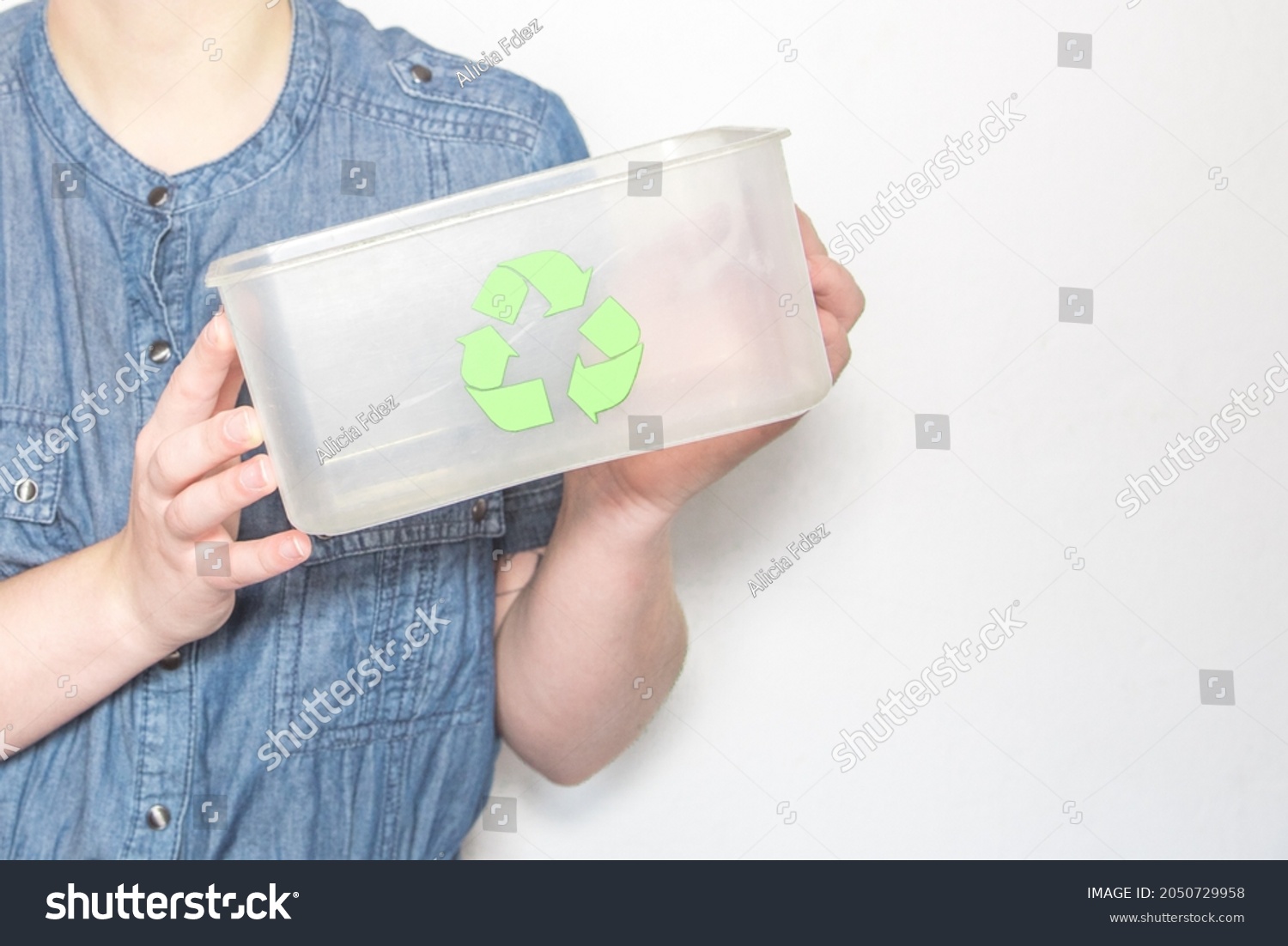 Caucasian woman holding an empty transparent box with the recycling symbol   #2050729958