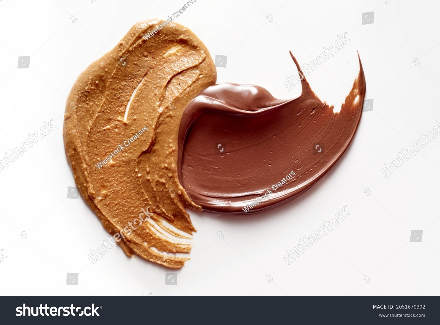 A closeup of delicious peanut butter and chocolate paste spread on white background #2051670392