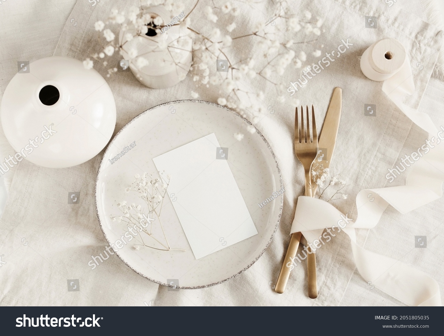 Blank paper sheet card mockup on minimal table place setting top view on beige linen tablecloth.  Space for text. Wedding invitation, menu. Scandinavian style. #2051805035