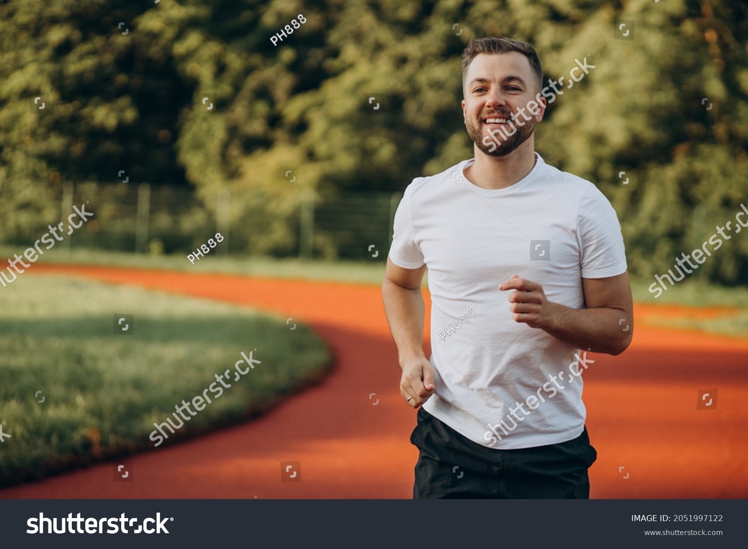 Man athlete jogging at stadium in the morning #2051997122