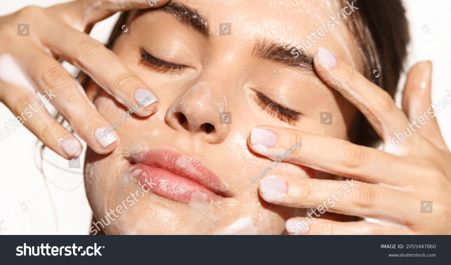 Close up portrait of beautiful woman clean her skin with cleansing gel, washing face and smiling from pleasure, standing over white background #2055447860