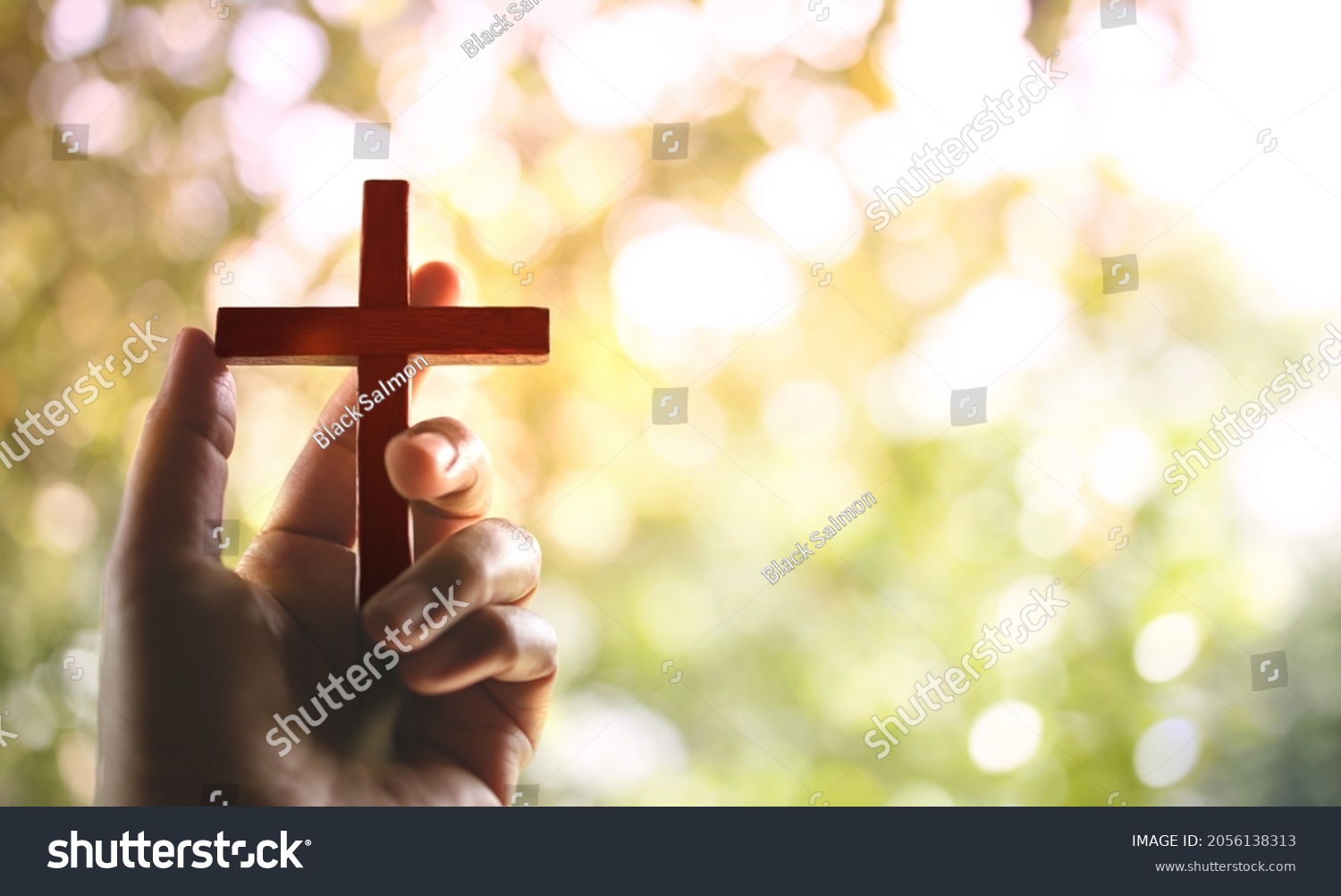 Spirituality and Religion Concept, Person Holding Christian Cross to Making Pray Outdoors. Believe and Faith for Christian People #2056138313