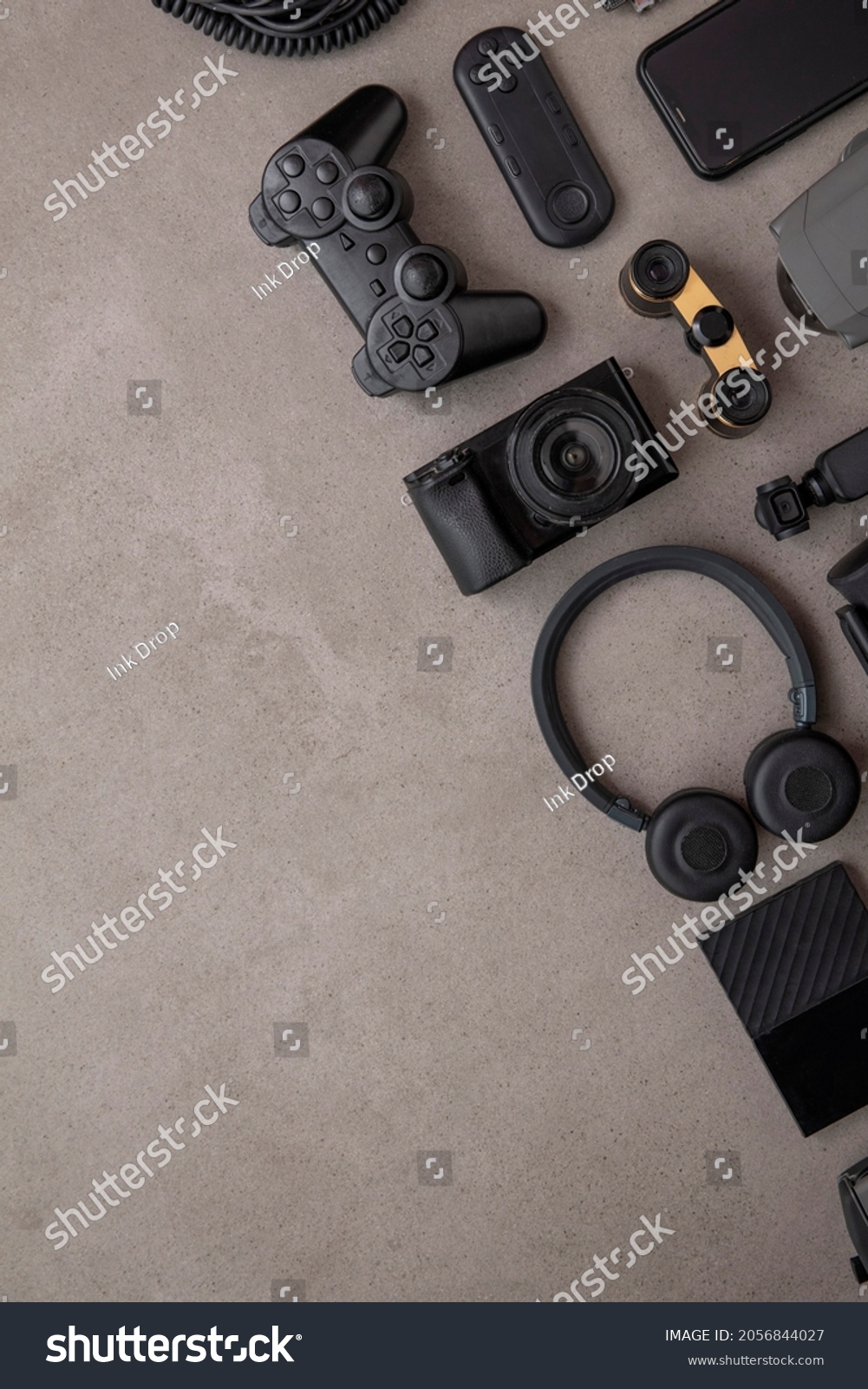 Overhead flat lay of black technology devices and gadgets on a grey background #2056844027