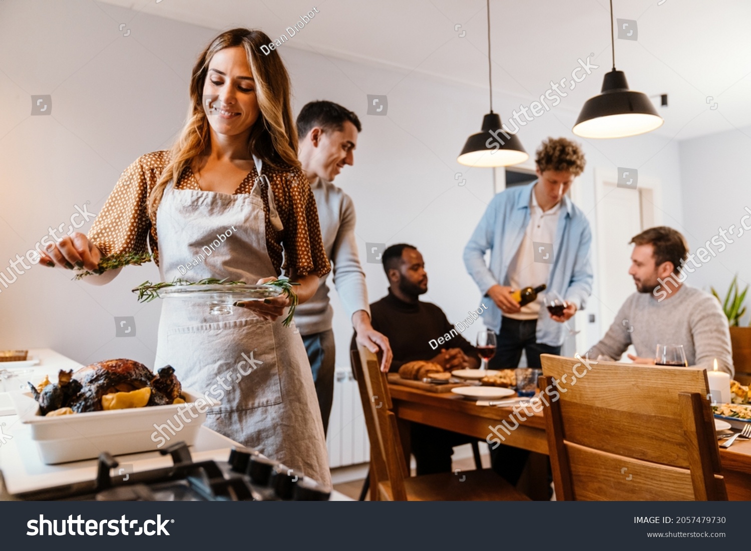 White couple cooking turkey for thanksgiving dinner with their friends at home #2057479730