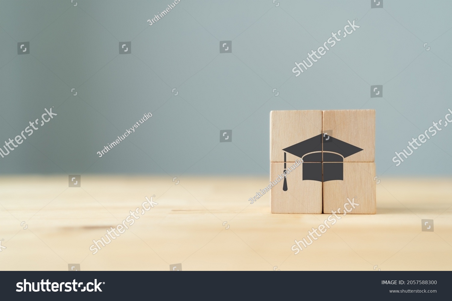 Graduation from university, education, diploma concept. Happiness cheerful feeling, Commencement, Graduation day. The wooden cubes with graduation cap on beautiful grey background and copy space. #2057588300