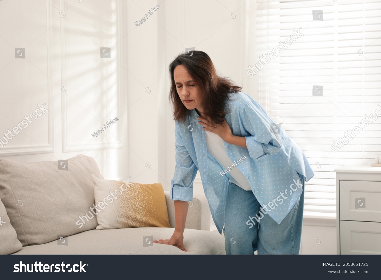 Mature woman suffering from breathing problem at home #2058651725