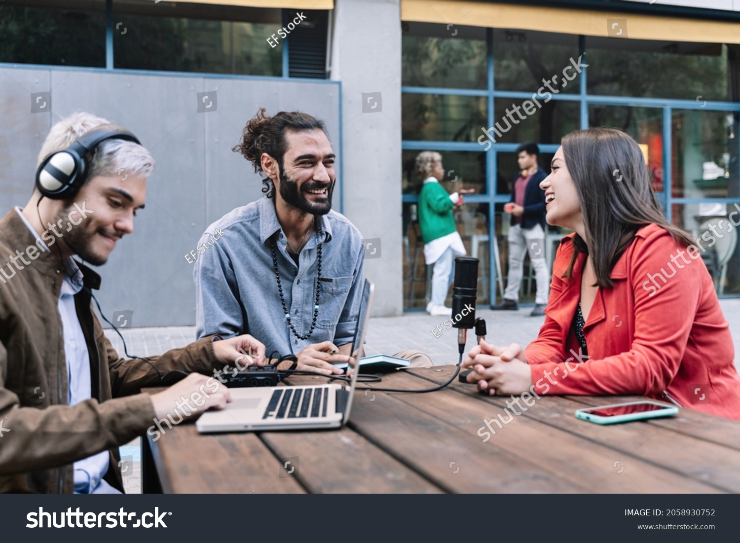 Young content creator journalist recording informal interview conversation with modern woman. Trendy millennial people making podcast for online social media radio networks. Focus on bearded man #2058930752