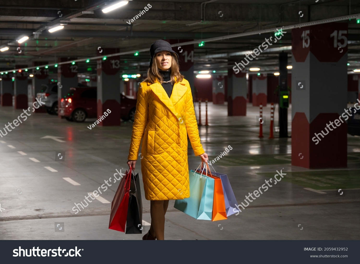 Shopper woman with purchases walking on the parking lot of shopping center. #2059432952