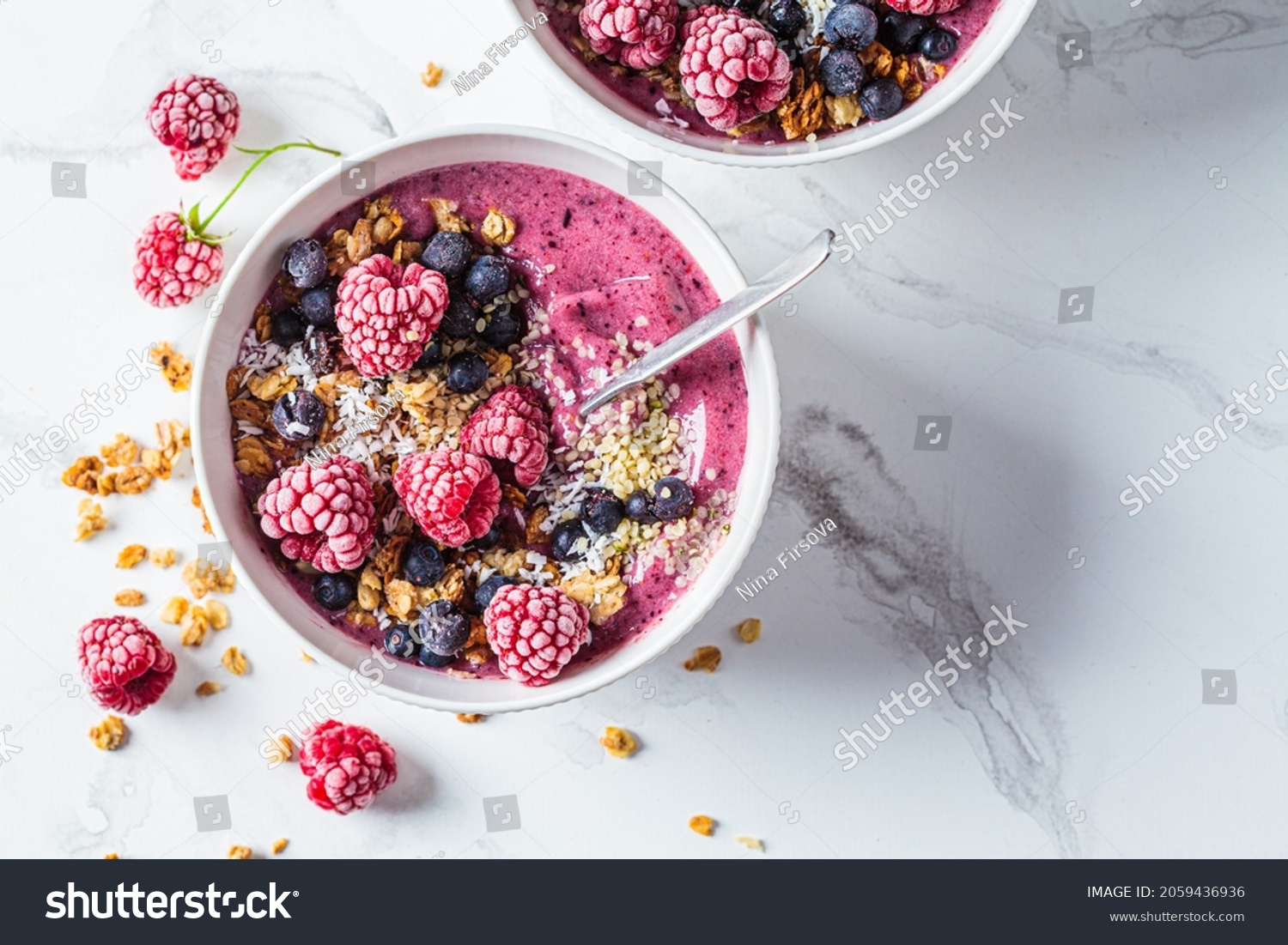 Berry smoothie bowl with granola, coconut and hemp seeds, white marble background, top view, close-up. Vegan food concept. #2059436936