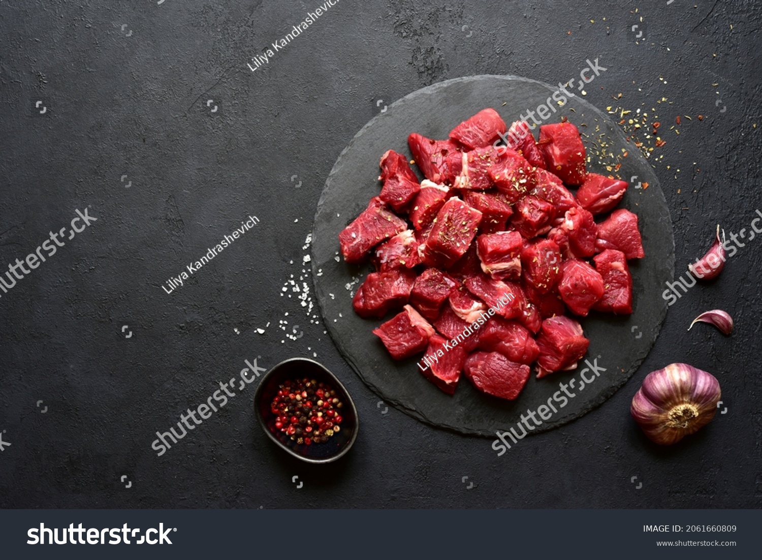 Raw organic meat ( beef or lamb ) on a black slate board. Top view with copy space. #2061660809