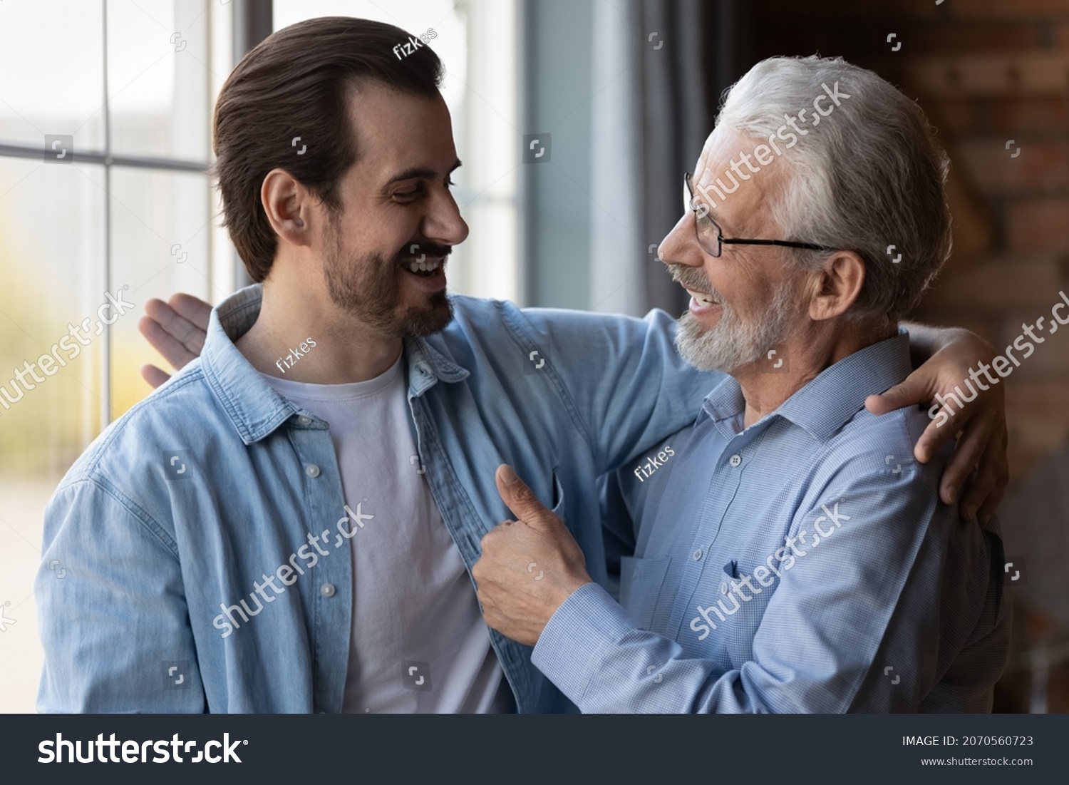 True friends. Excited elderly dad embrace adult son glad to hear good news congratulate with success show thumb up. Happy older age male proud of grown child achievement support approve young man deed #2070560723