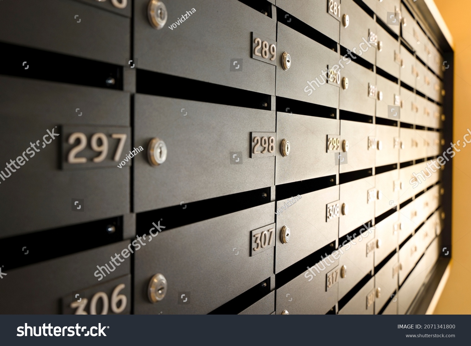 Mailboxes for letters and correspondence. Modern black mailboxes with numbers in the lobby of a residential or office building #2071341800