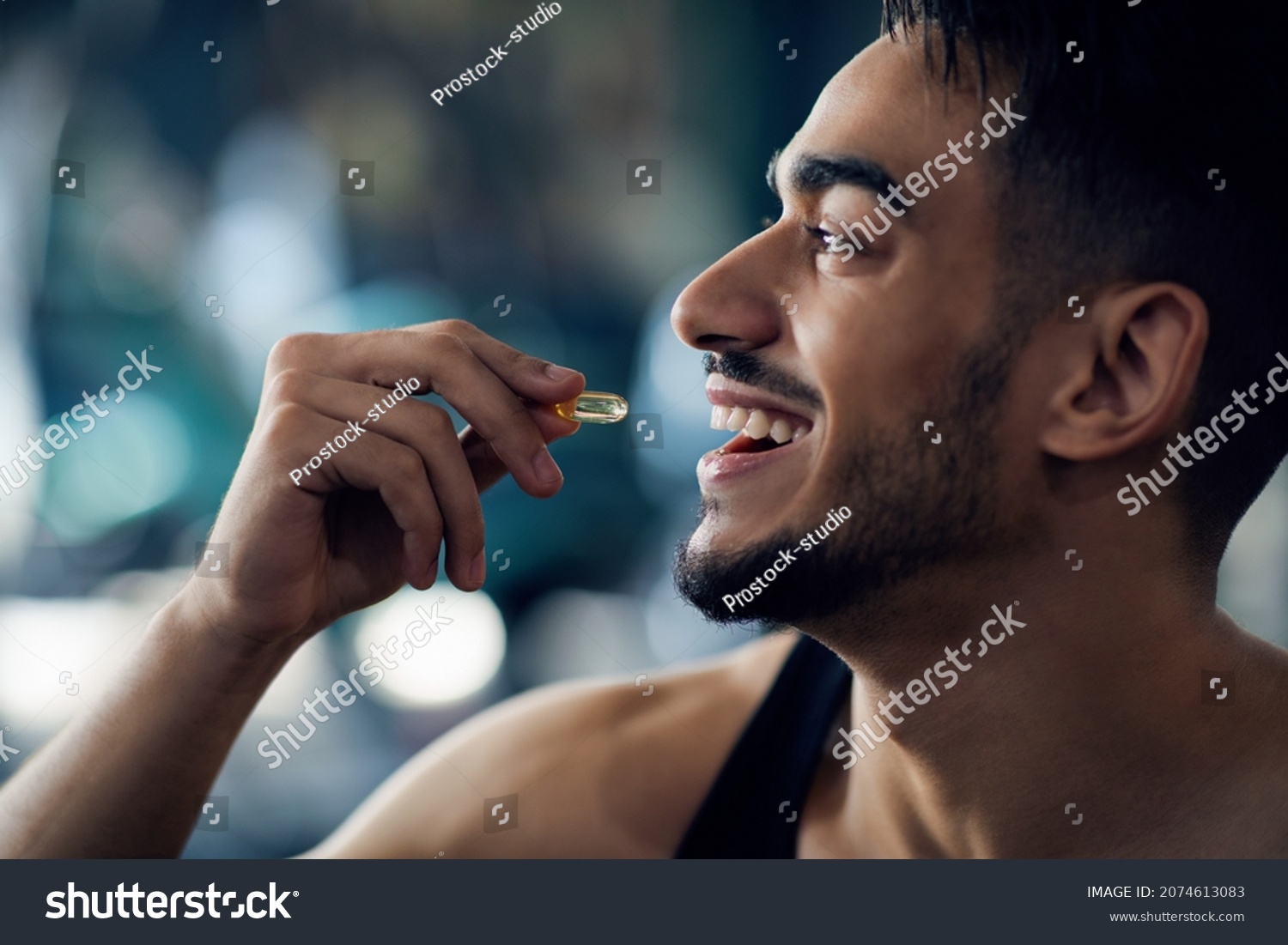 Portrait Of Happy Sportive Arab Man Taking Supplement Capsule, Closeup Shot Of Young Middle Eastern Guy Eating Omega 3 Or Amino Acid Multivitamin Pill, Enjoying Fitness Nutrition, Cropped #2074613083
