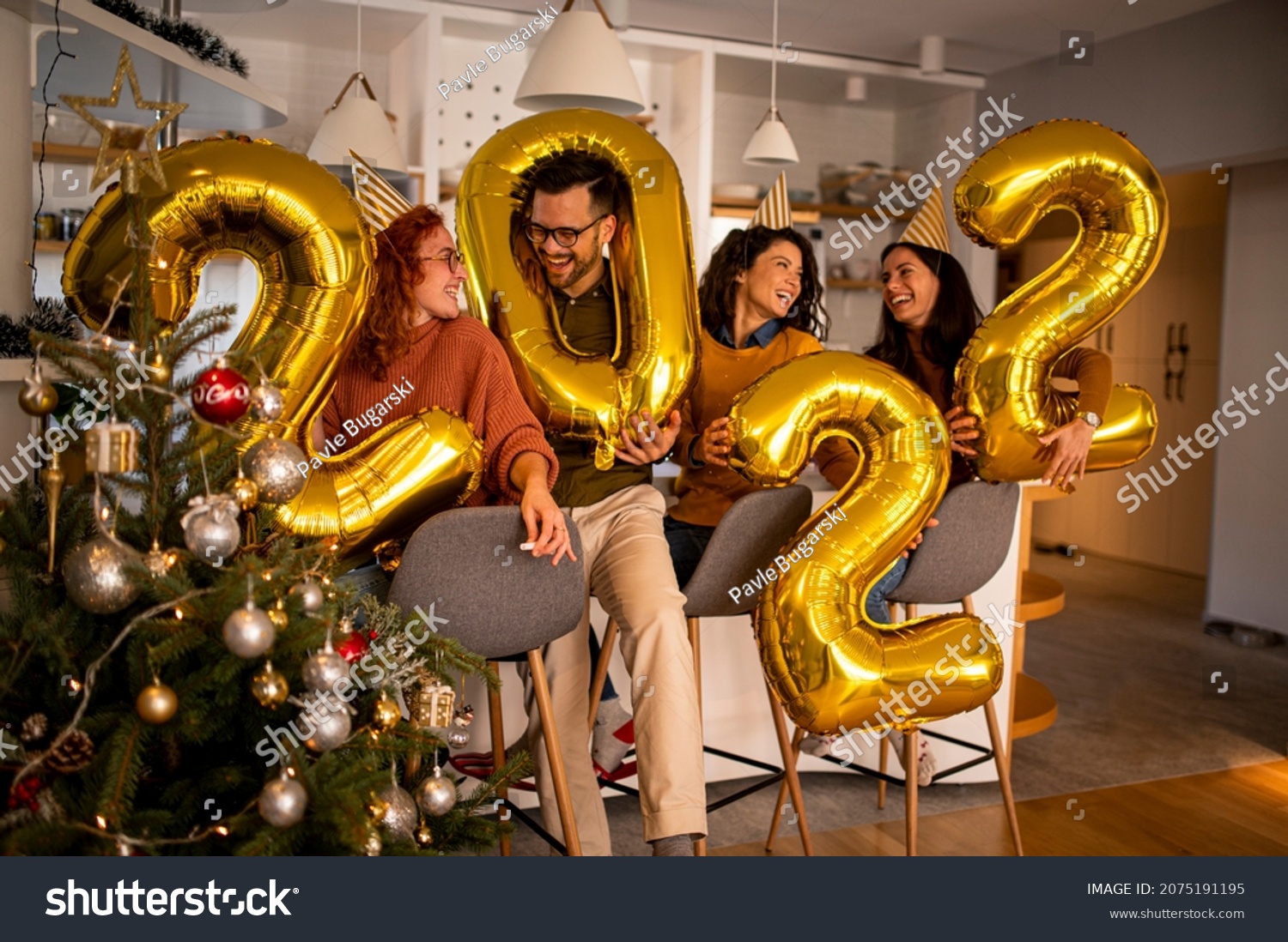 Group of young beautiful people in casual clothing carrying gold colored numbers and smiling #2075191195