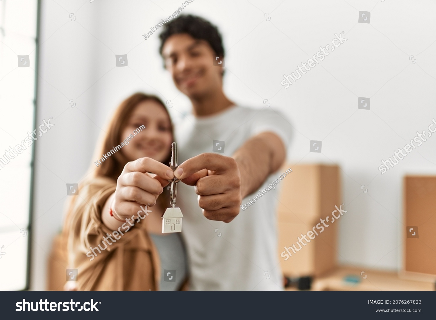 Young couple smiling happy holding key of new home. #2076267823