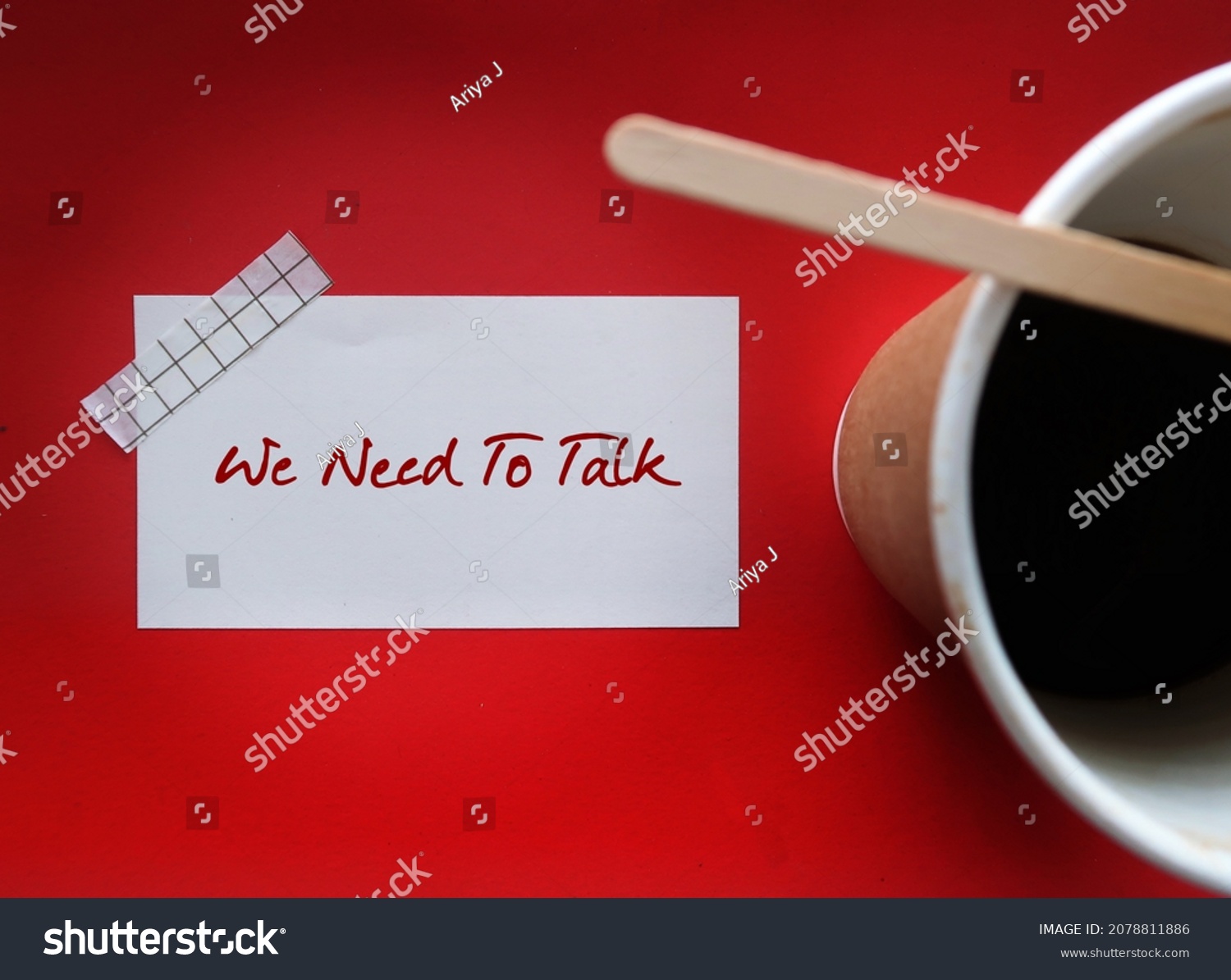 Coffee cup on red background with note written WE NEED TO TALK, means there is a serious problem that needs to be discussed, partners serious conversation generally followed by relationship ending #2078811886