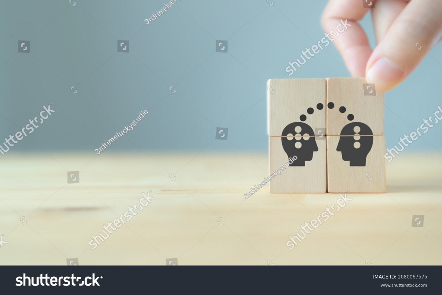 Knowledge and ideas sharing between two people head icon on wooden cube. Transferring knowledge, innovation, brainstorming concept. Business strategies to technology evolution re-skill and new skill.  #2080067575