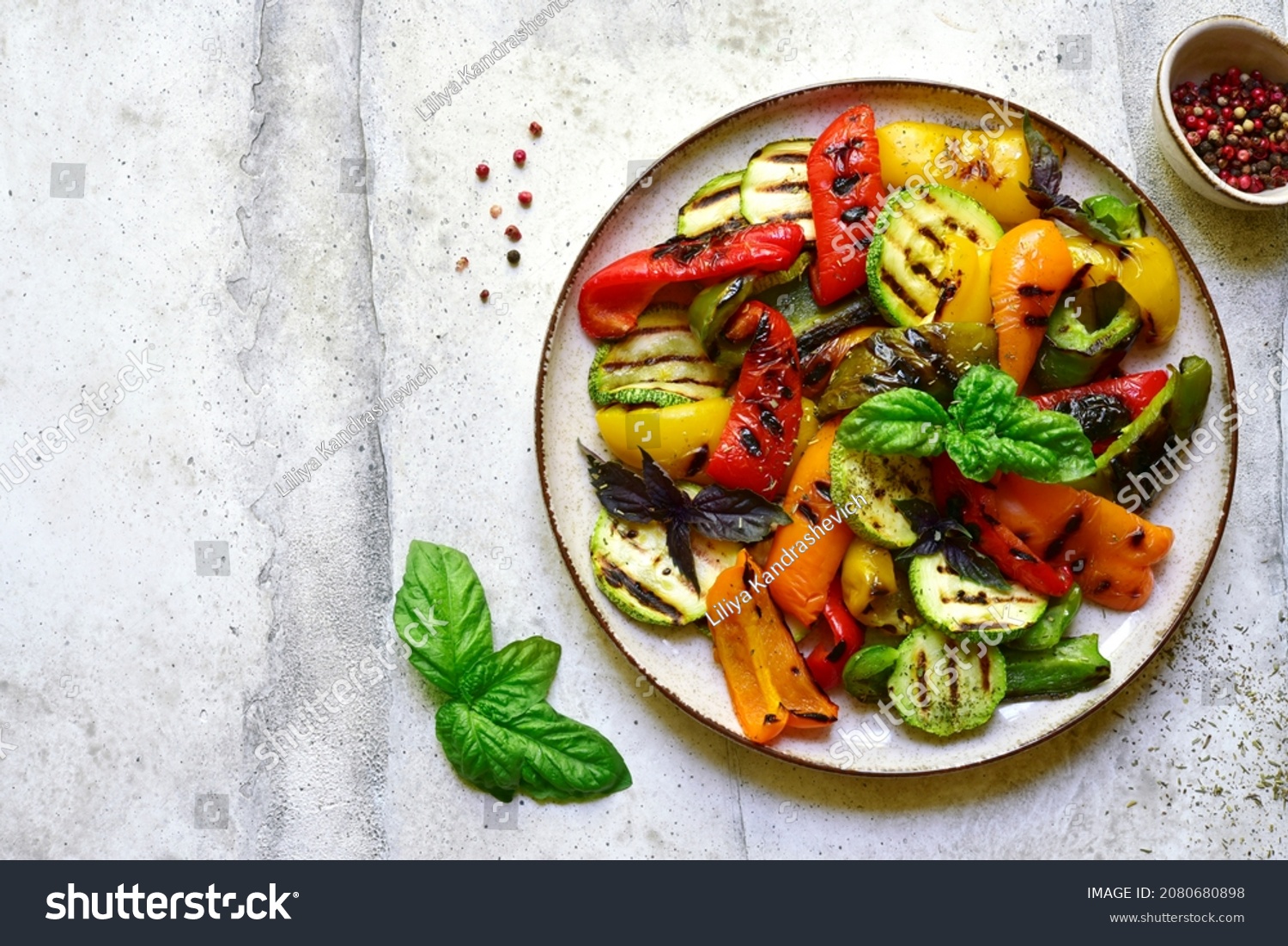 Grilled colorful vegetable : bell pepper, zucchini, eggplant on a plate over light grey slate, stone or concrete background. Top view with copy space. #2080680898