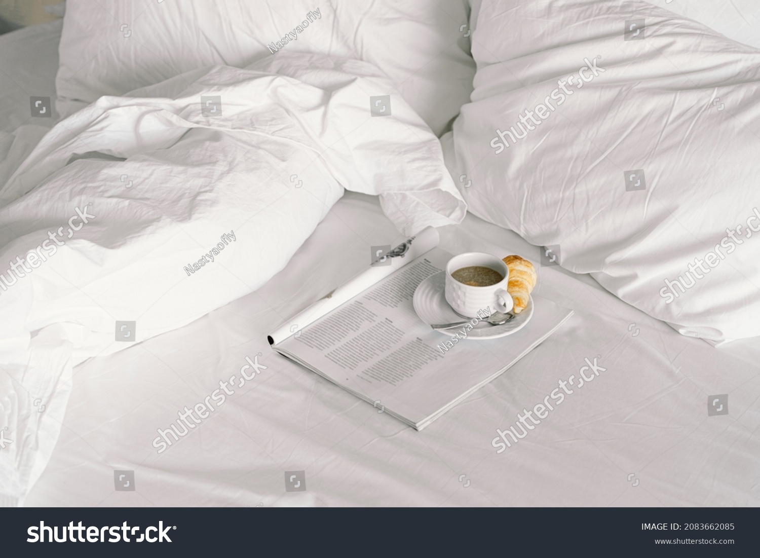 Breakfast on the bed in the hotel room. Breakfast in a snow-white bed, coffee with a croissant. Cozy morning. Breakfast in bed. #2083662085